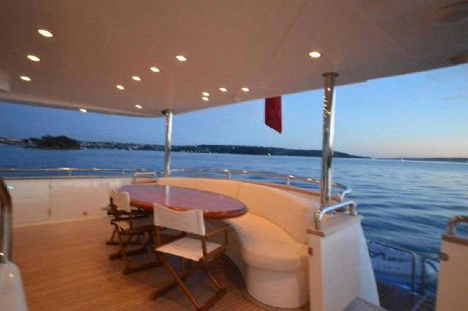 a table and chairs on a deck aboard ENCORE Yacht for Sale