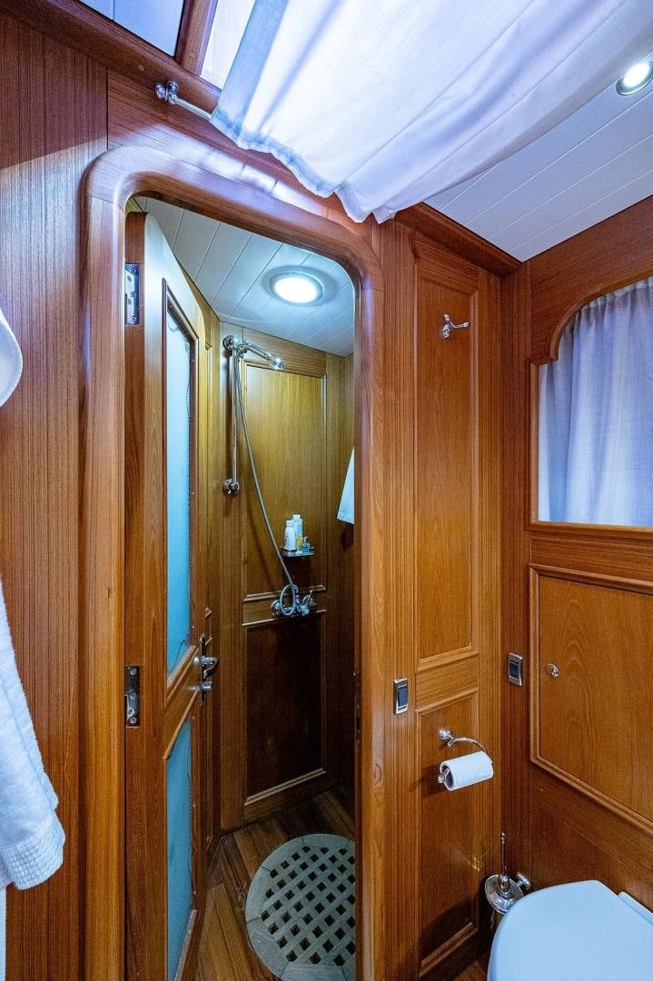 a bathroom with a wood door aboard ATALI Yacht for Sale