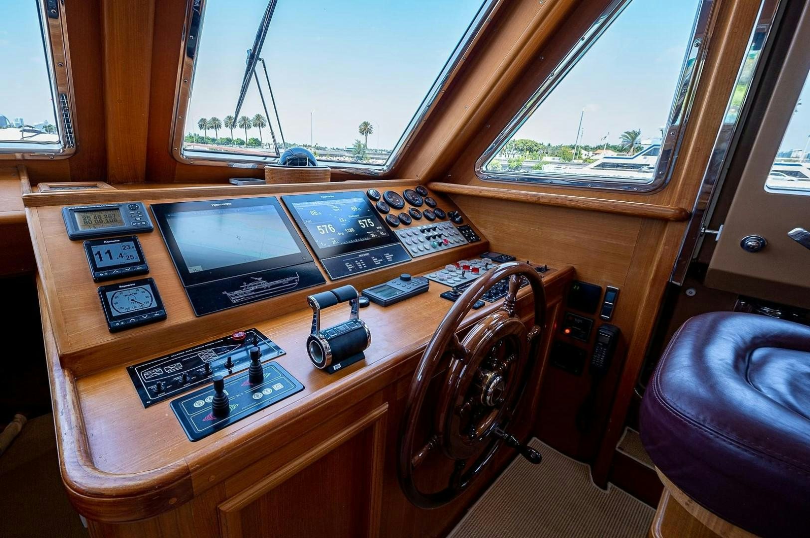 a wooden desk with a computer and other electronics on it aboard ATALI Yacht for Sale