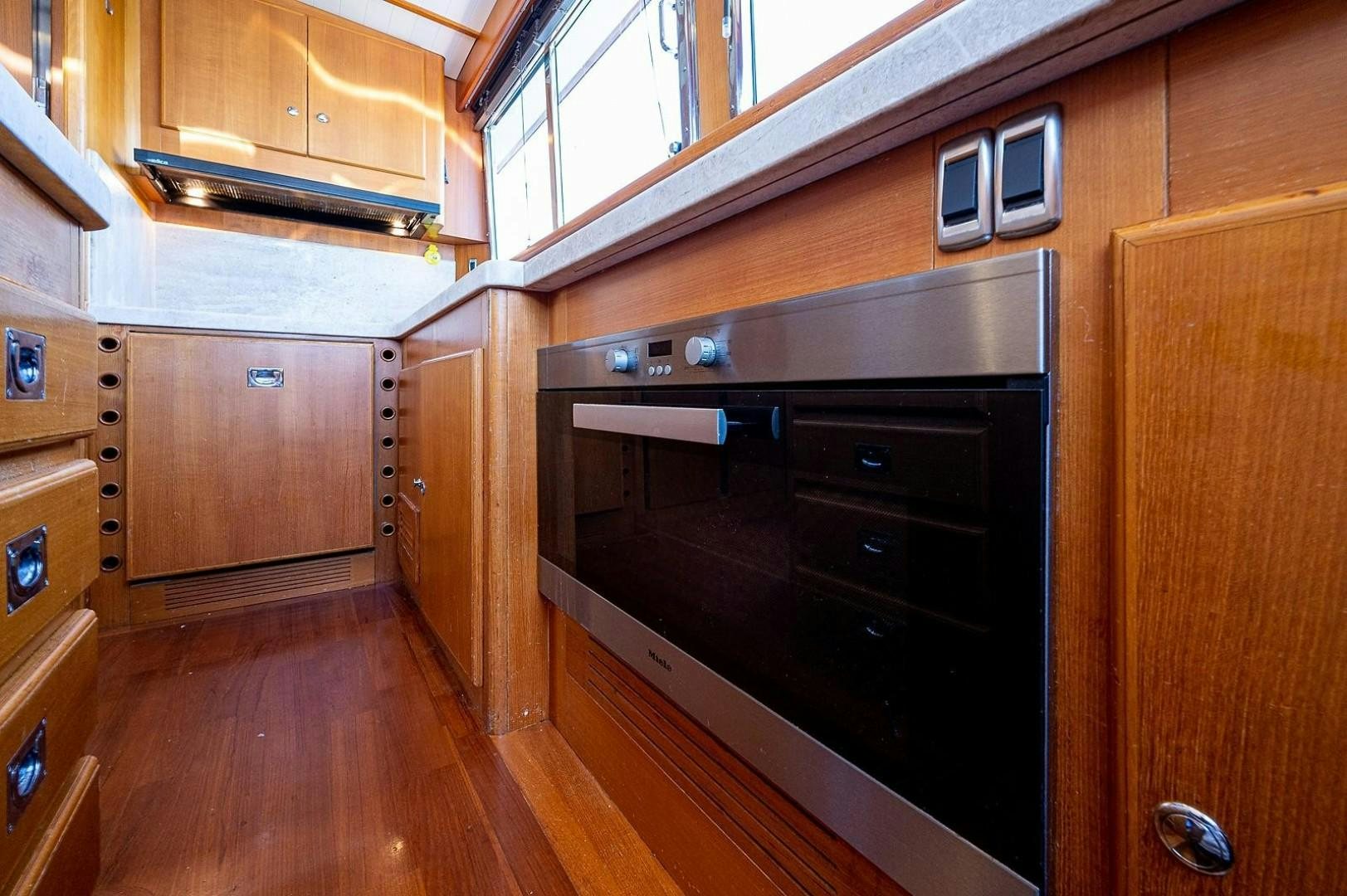 a kitchen with wooden cabinets aboard ATALI Yacht for Sale