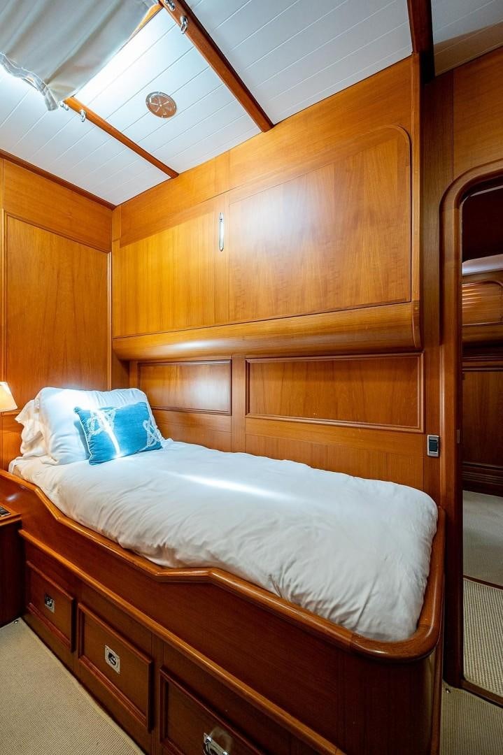 a bed with a wooden headboard aboard ATALI Yacht for Sale