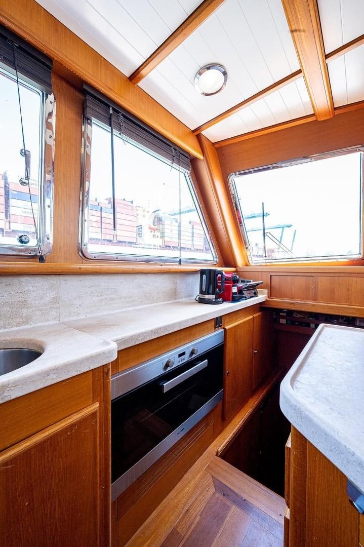a kitchen with wooden cabinets aboard ATALI Yacht for Sale