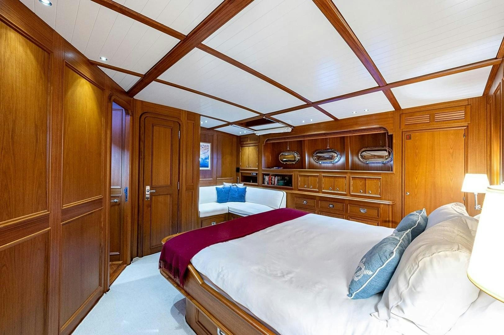 a room with a bed and a wood cabinet aboard ATALI Yacht for Sale