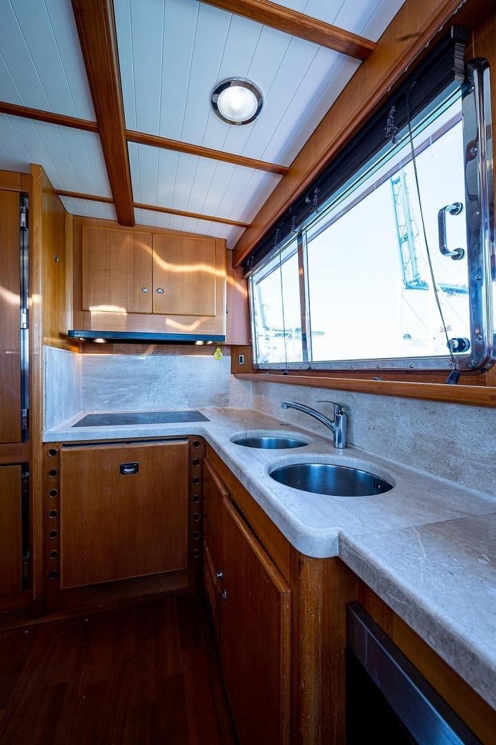 a kitchen with wooden cabinets aboard ATALI Yacht for Sale