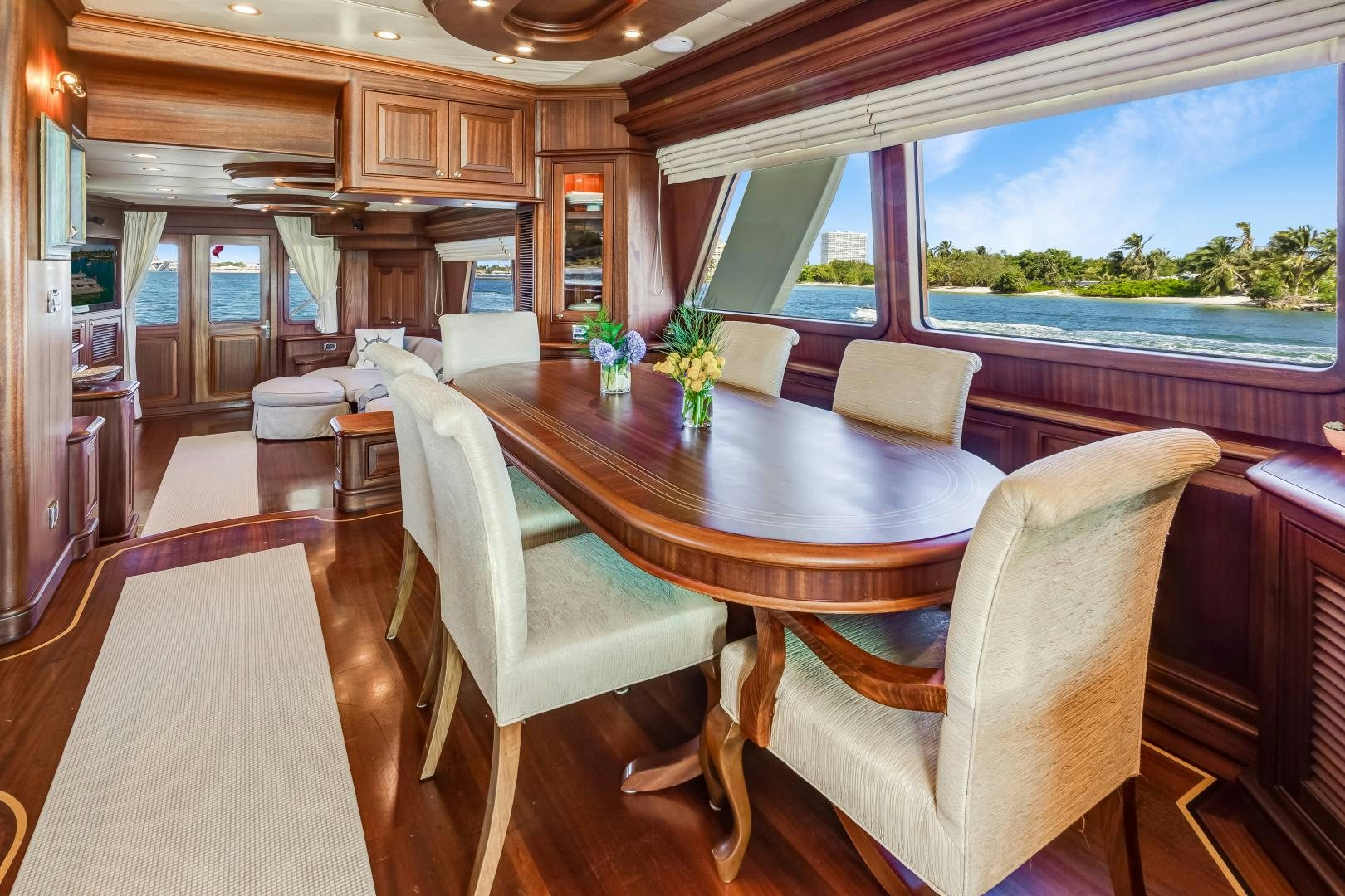 a dining table and chairs in a room with a large window aboard CHANSON II Yacht for Sale