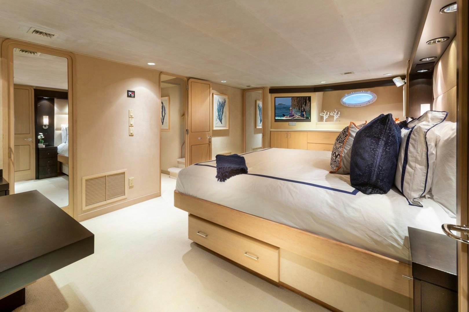 a bedroom with a bed and desk aboard CRU Yacht for Sale