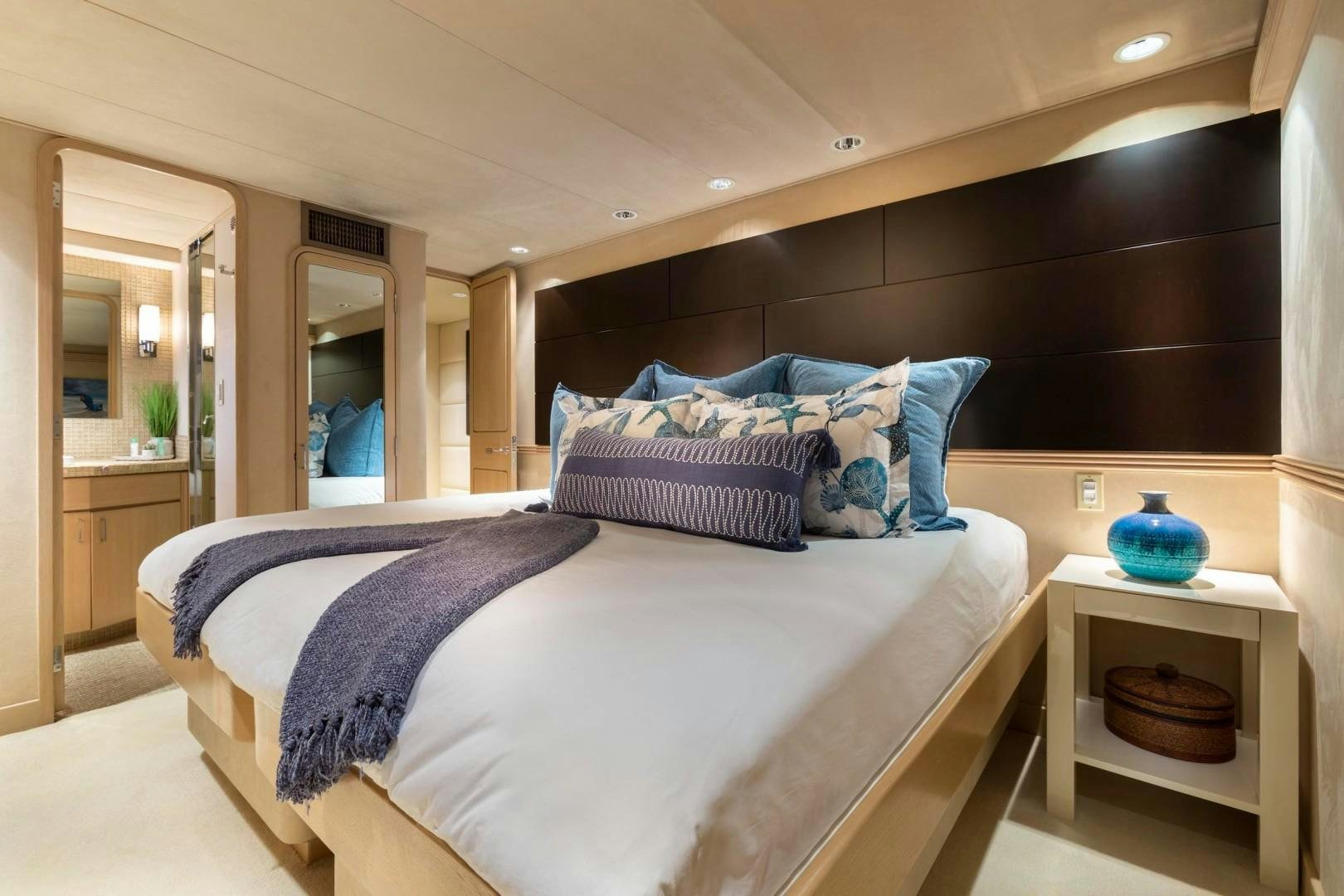 a bed with blue and white sheets aboard CRU Yacht for Sale