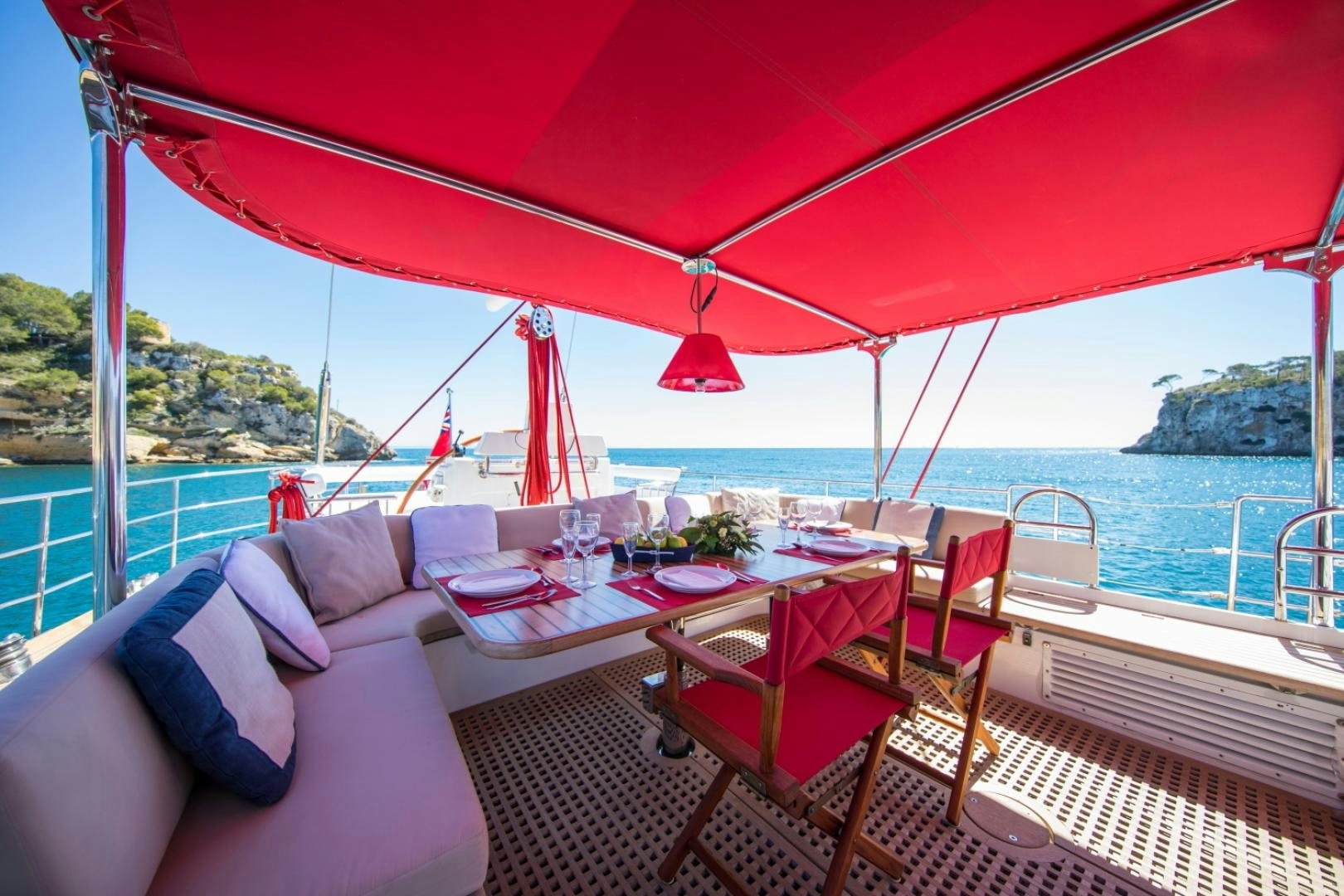 a table and chairs on a balcony overlooking a body of water aboard ALTA MAREA Yacht for Sale