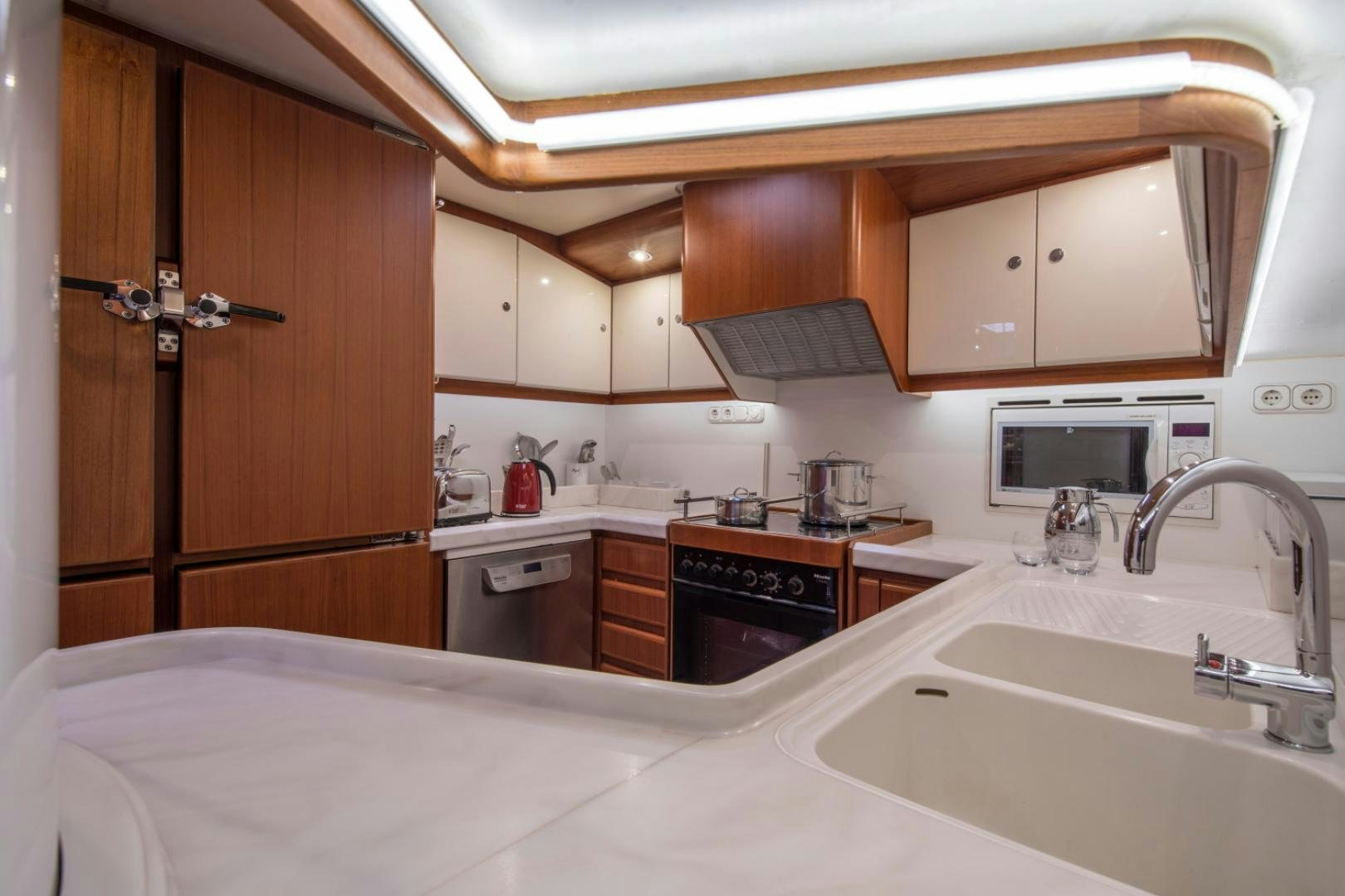 a kitchen with white cabinets aboard ALTA MAREA Yacht for Sale