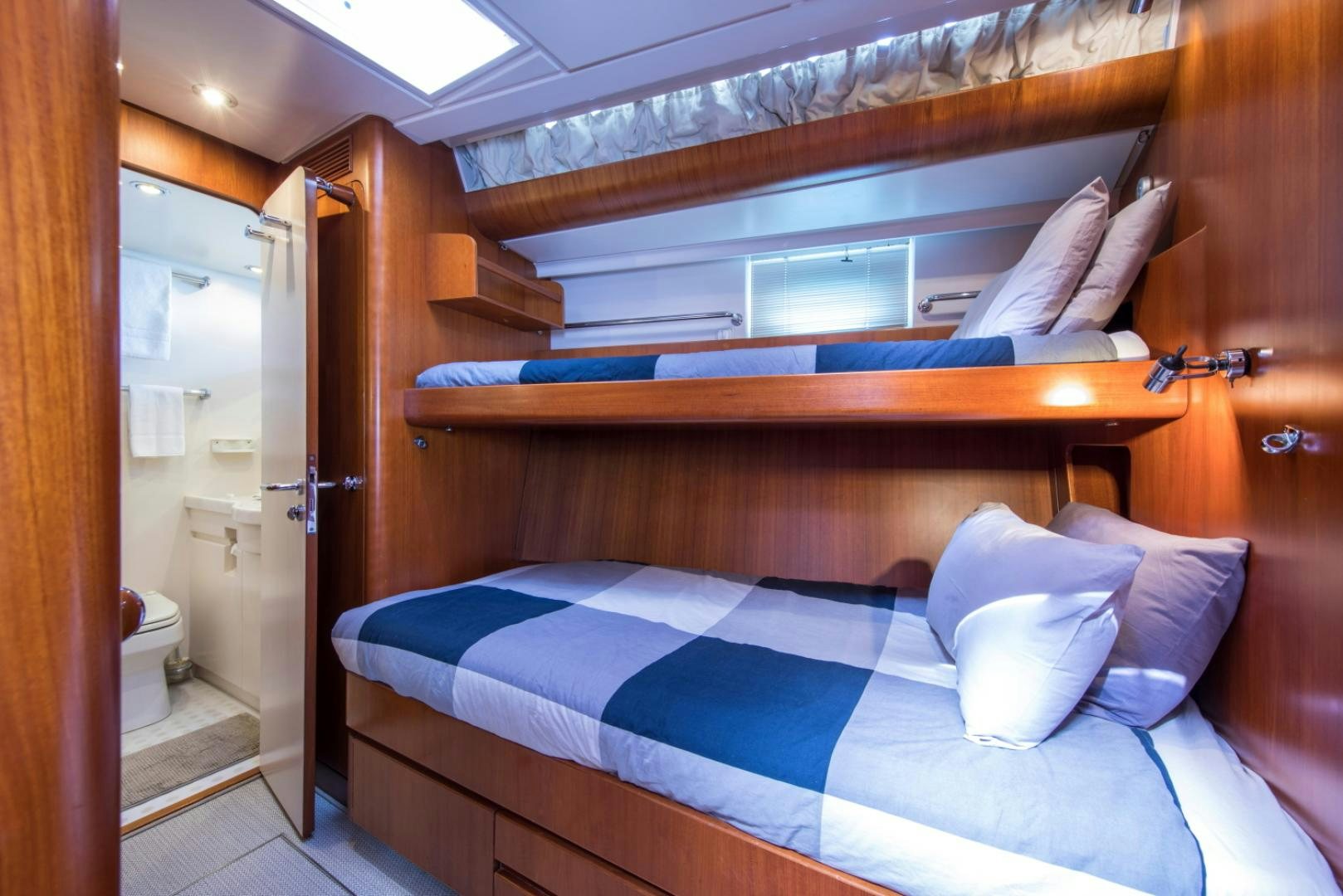 a bed with a blue and white pillow on it aboard ALTA MAREA Yacht for Sale