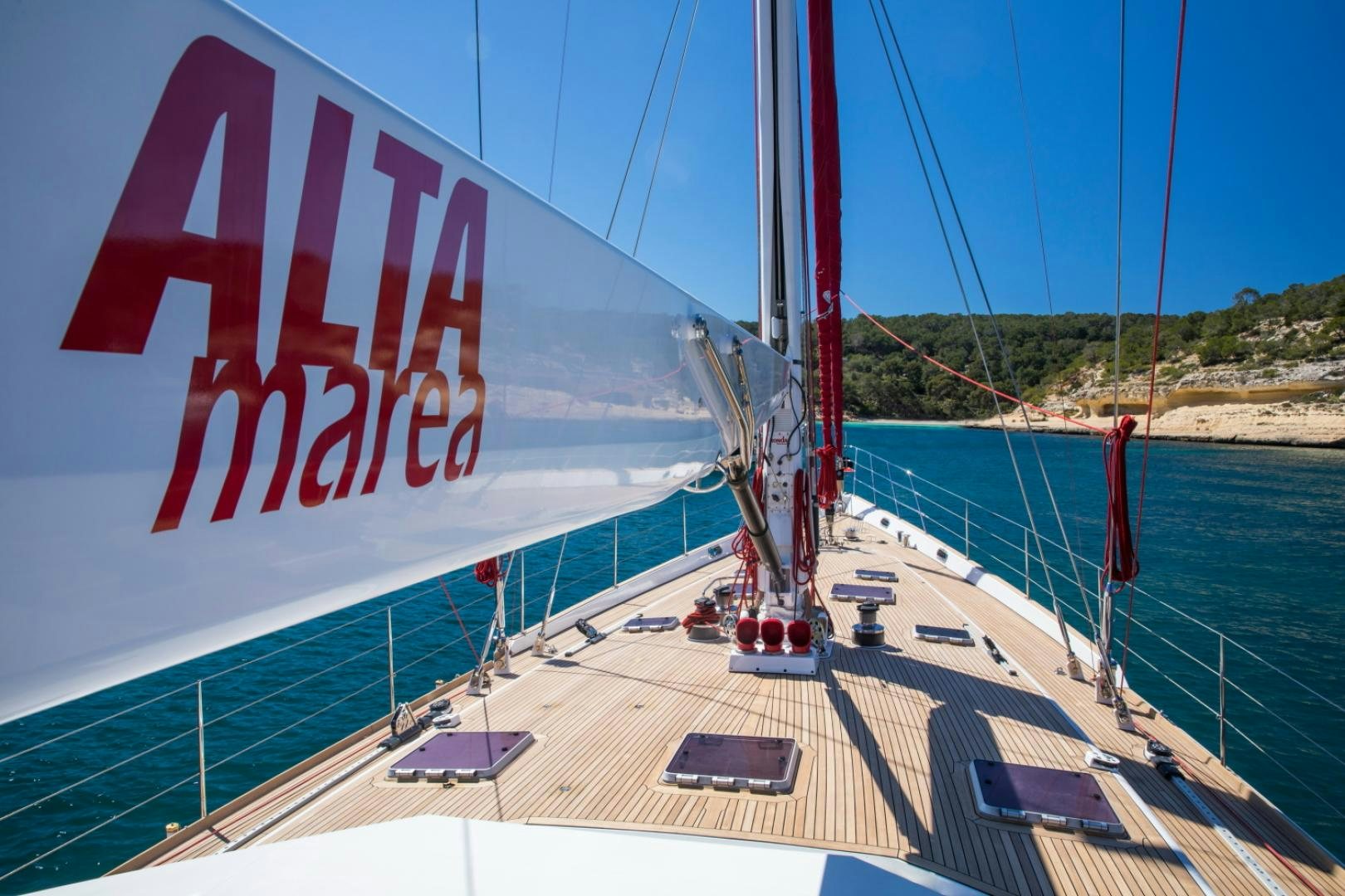 a large white and red sailboat on a blue water body aboard ALTA MAREA Yacht for Sale