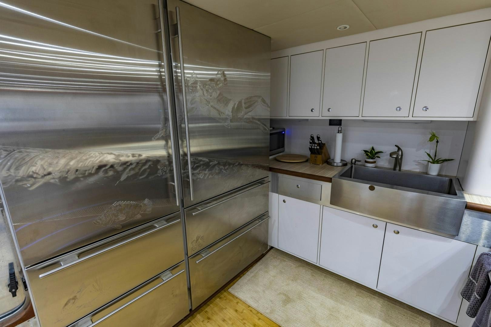 a kitchen with white cabinets aboard RESET Yacht for Sale