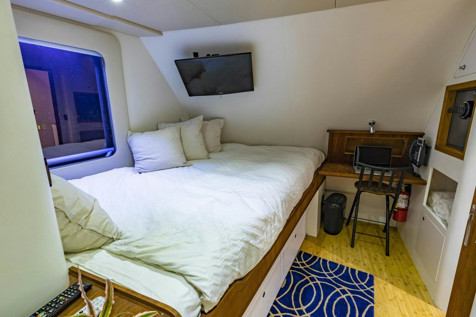 a bedroom with a bed and a television aboard RESET Yacht for Sale