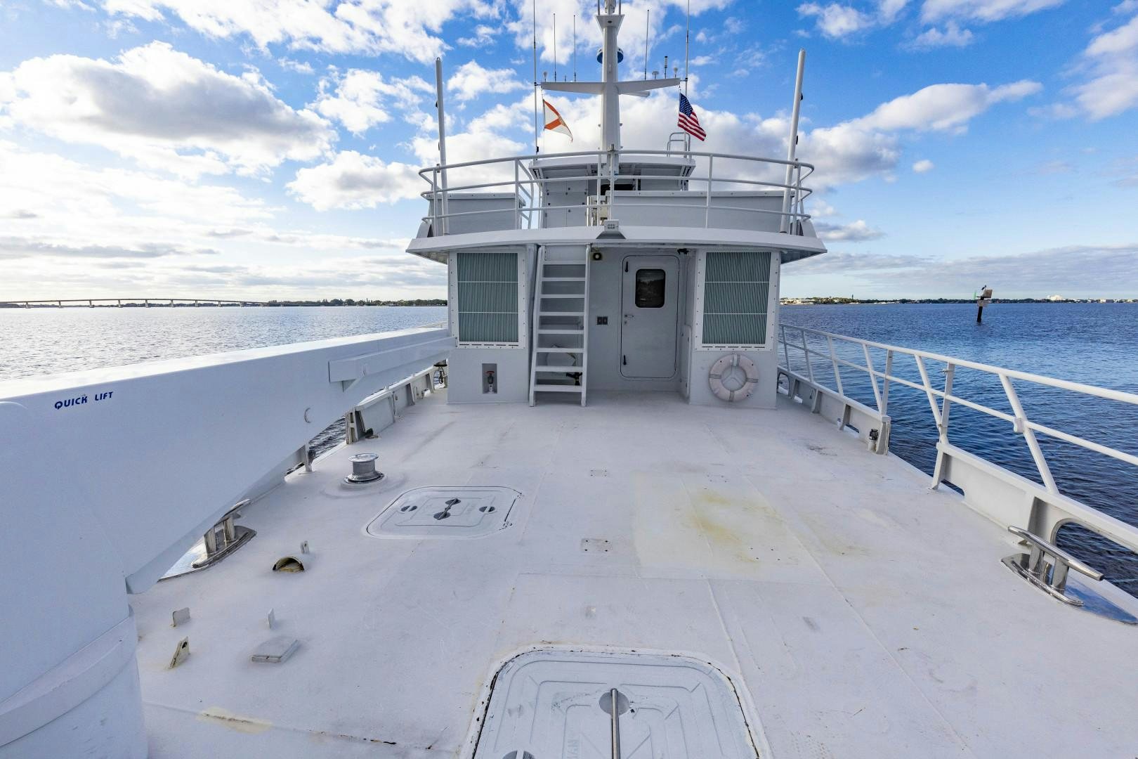 a white building with a flag on it and a person standing on the side of it aboard RESET Yacht for Sale