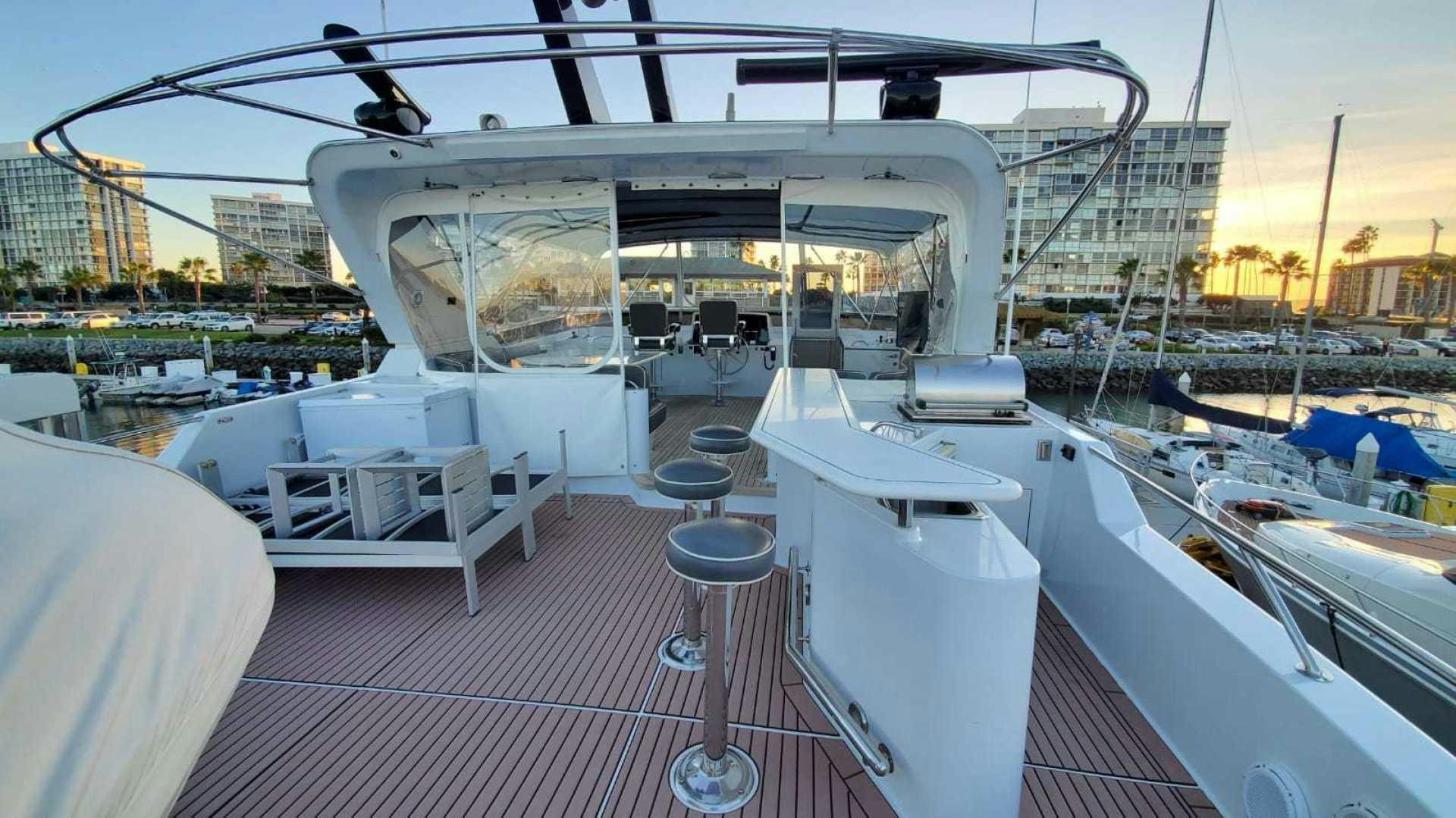 a deck with a table and chairs on it aboard LA LA LAND Yacht for Sale