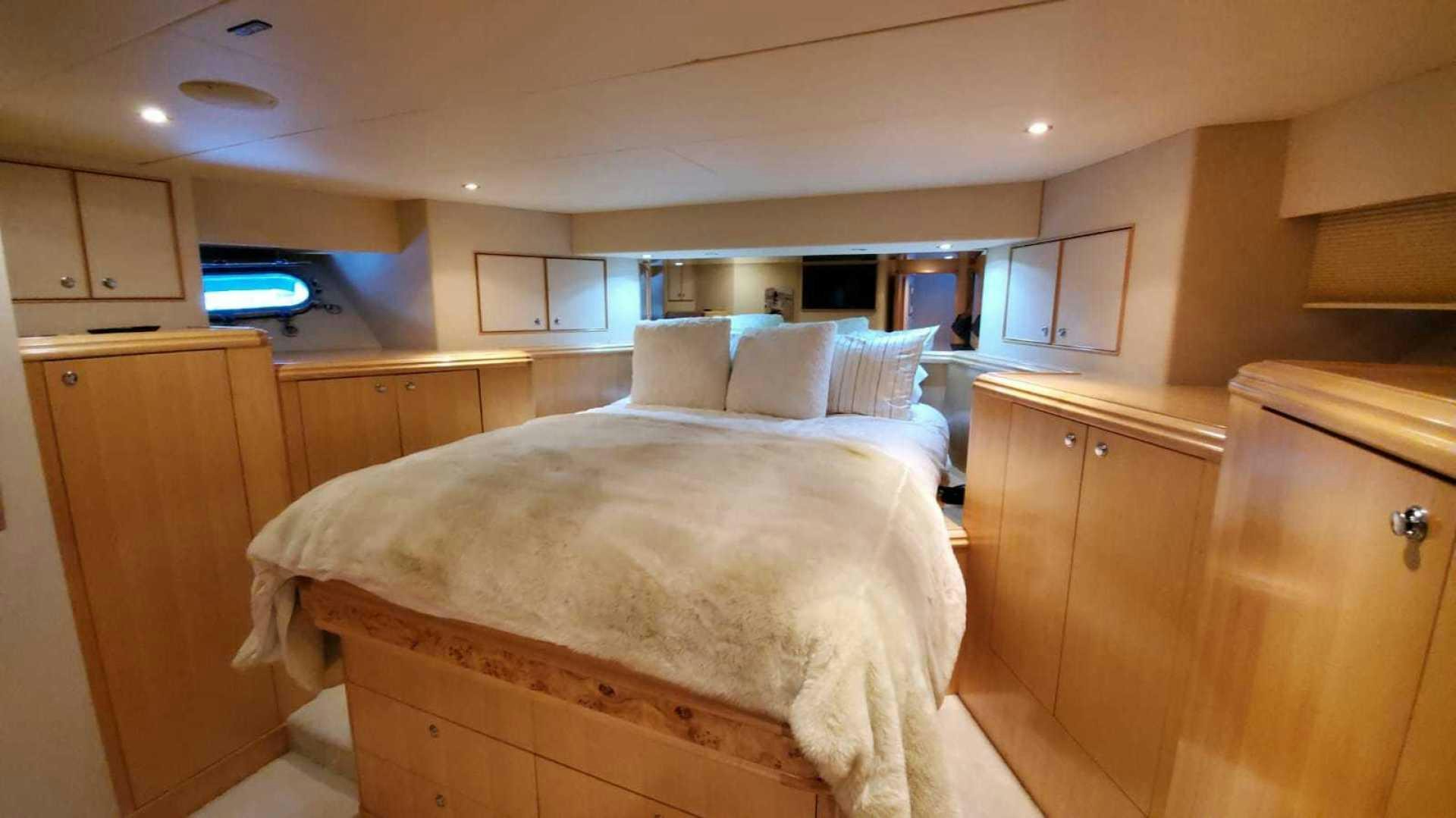 a bedroom with a bed and cabinets aboard LA LA LAND Yacht for Sale