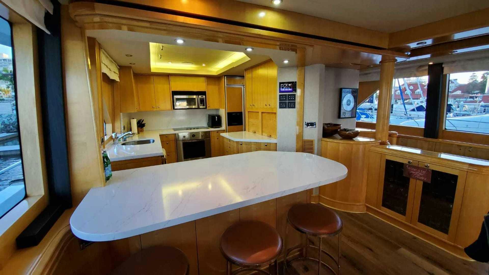 a kitchen with a table and stools aboard LA LA LAND Yacht for Sale