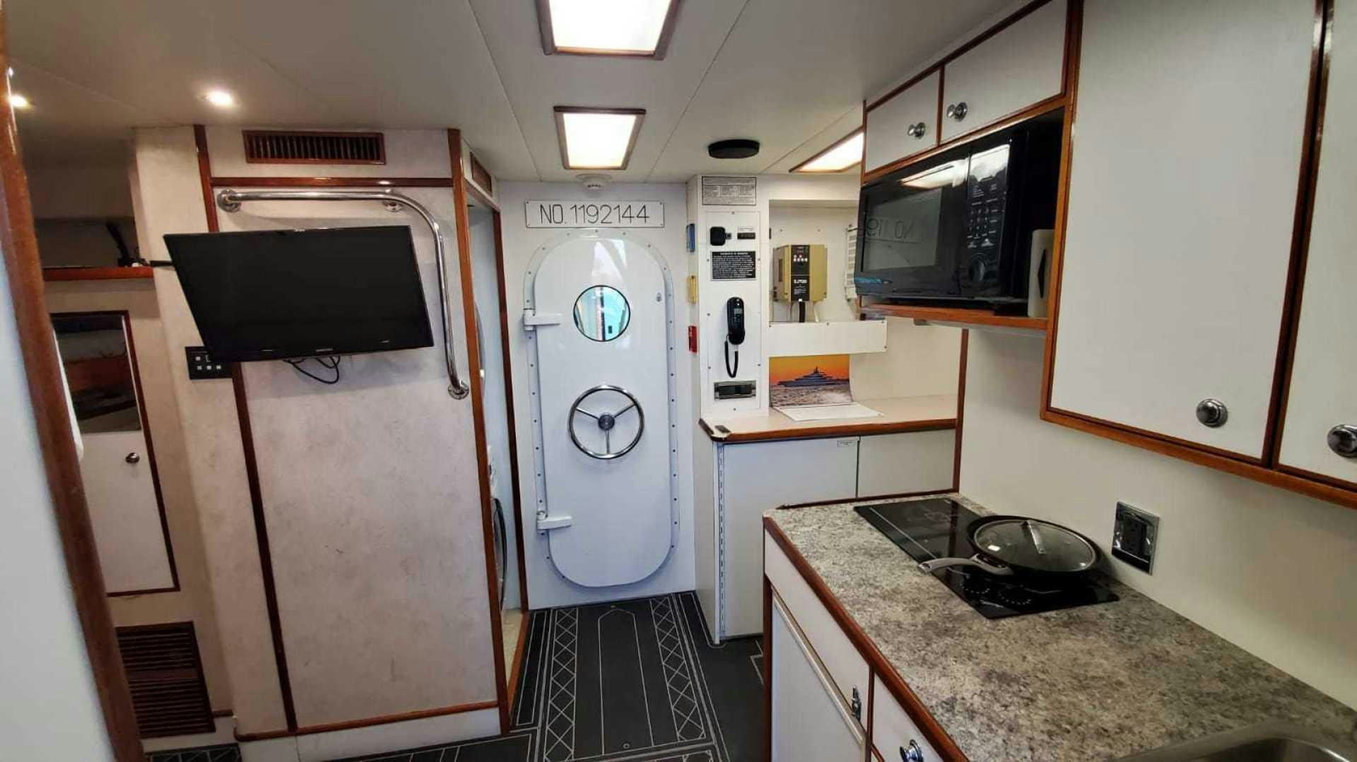 a kitchen with a washing machine and microwave aboard LA LA LAND Yacht for Sale
