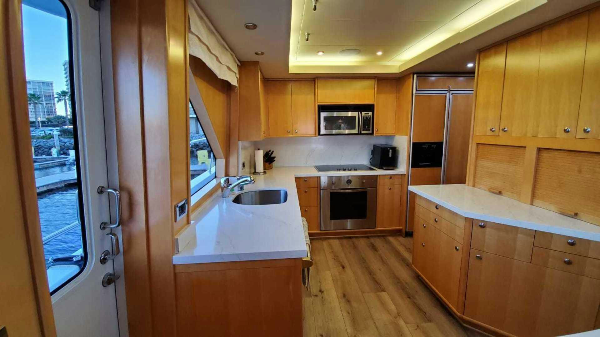 a kitchen with wooden cabinets aboard LA LA LAND Yacht for Sale