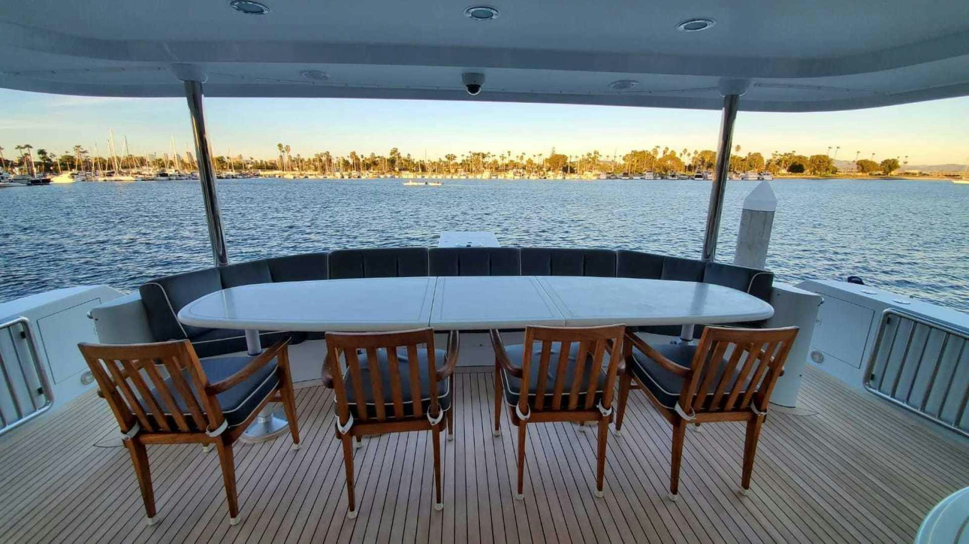a group of chairs on a deck overlooking a body of water aboard LA LA LAND Yacht for Sale