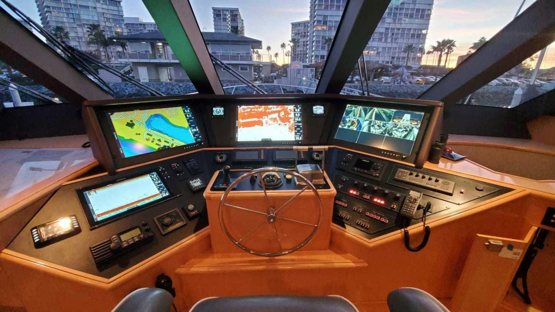 a room with many screens and a table with chairs and a lamp aboard LA LA LAND Yacht for Sale