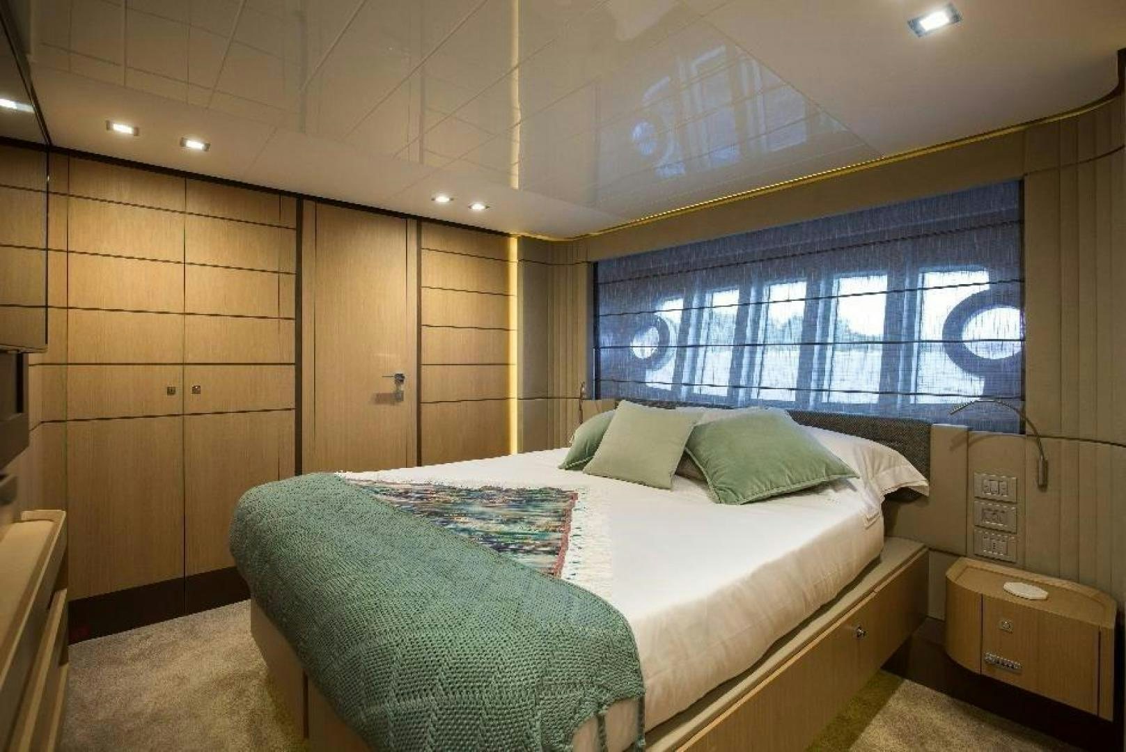 a bedroom with a bed and a window aboard HAPPY BLUE II Yacht for Sale