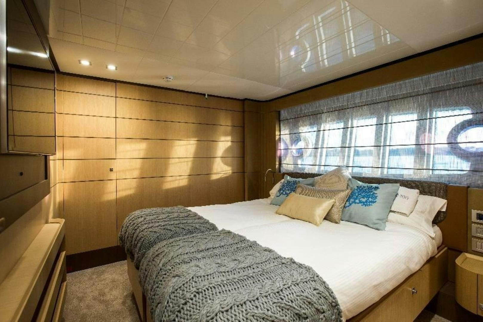 a bedroom with a bed and a window aboard HAPPY BLUE II Yacht for Sale