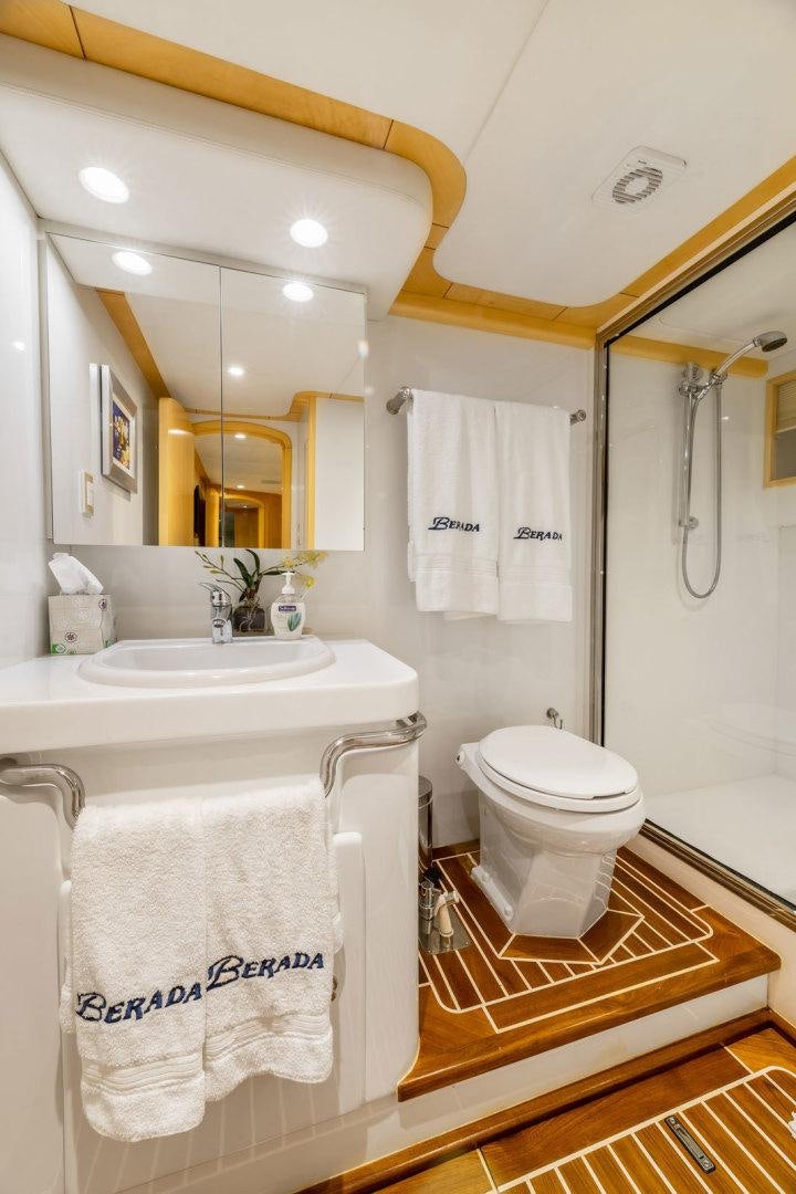 a bathroom with a sink toilet and a mirror aboard BERADA Yacht for Sale