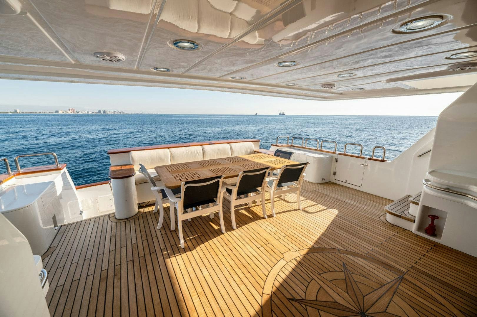 a deck with a table and chairs aboard BERADA Yacht for Sale