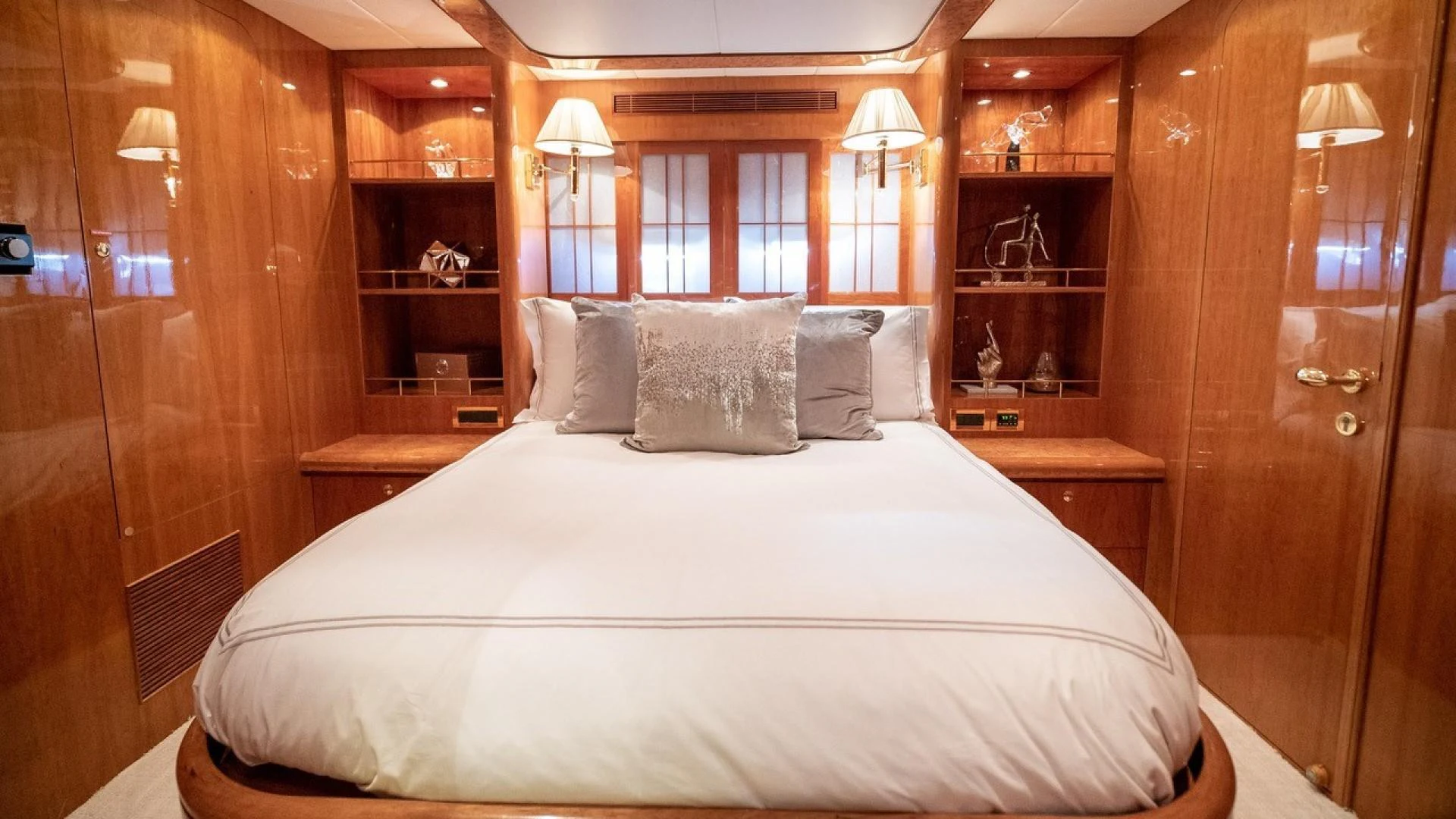 a bed with pillows and a lamp aboard TRITON Yacht for Sale