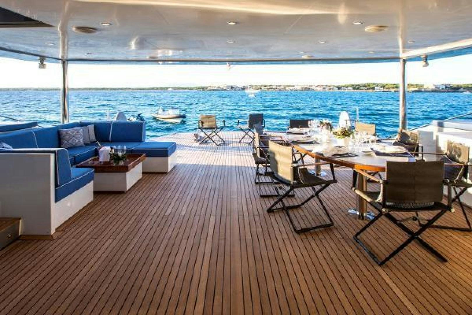 a room with a table chairs and a large body of water aboard CARTOUCHE Yacht for Sale