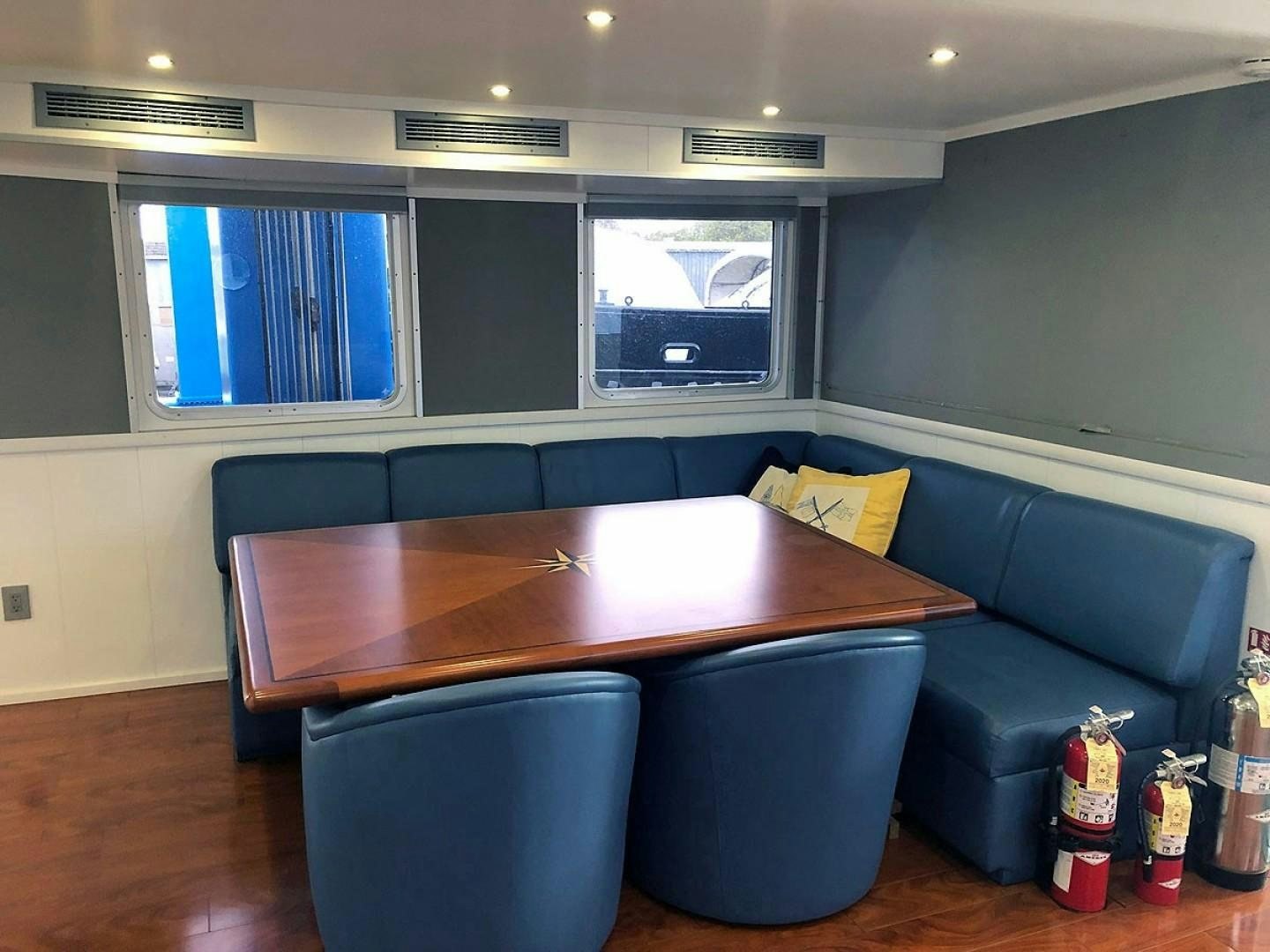 a room with a table and chairs aboard CARE BEAR Yacht for Sale