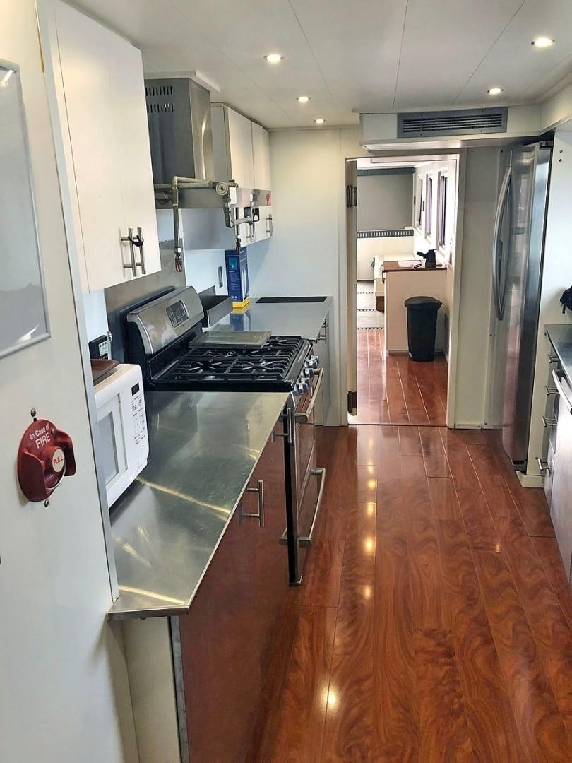 a kitchen with a wood floor aboard CARE BEAR Yacht for Sale