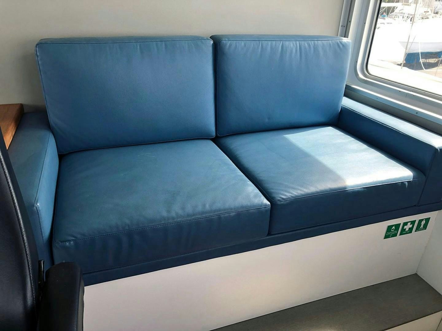 a blue couch with a white seat aboard CARE BEAR Yacht for Sale