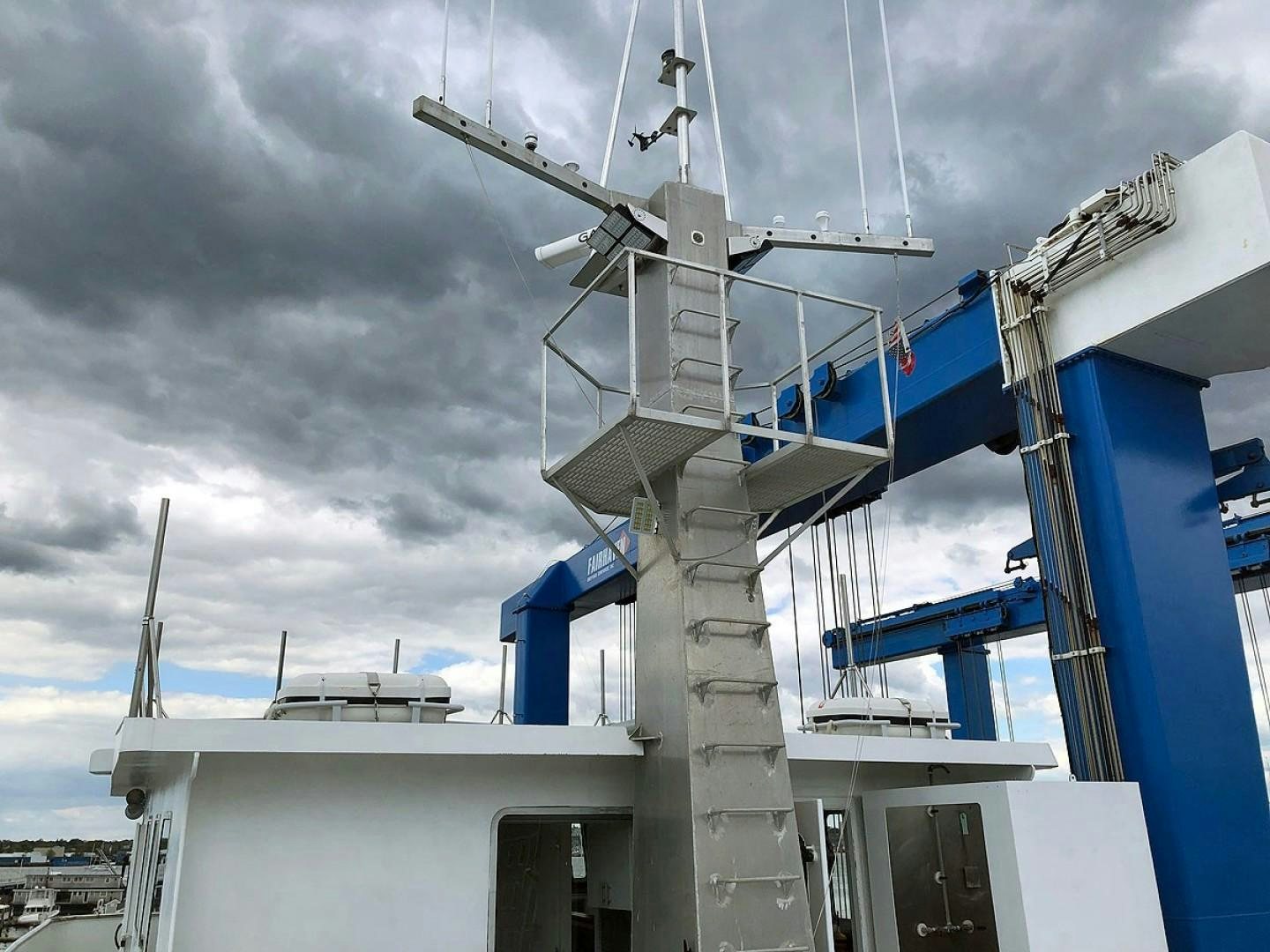 a white building with a blue roof and a white building with a blue roof and a cloudy sky aboard CARE BEAR Yacht for Sale