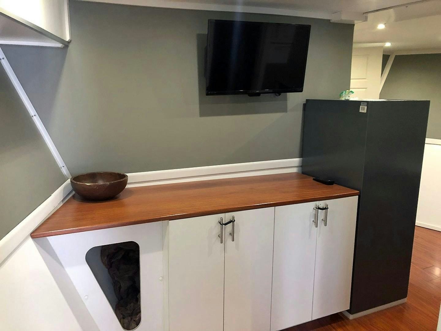 a kitchen with a black refrigerator aboard CARE BEAR Yacht for Sale