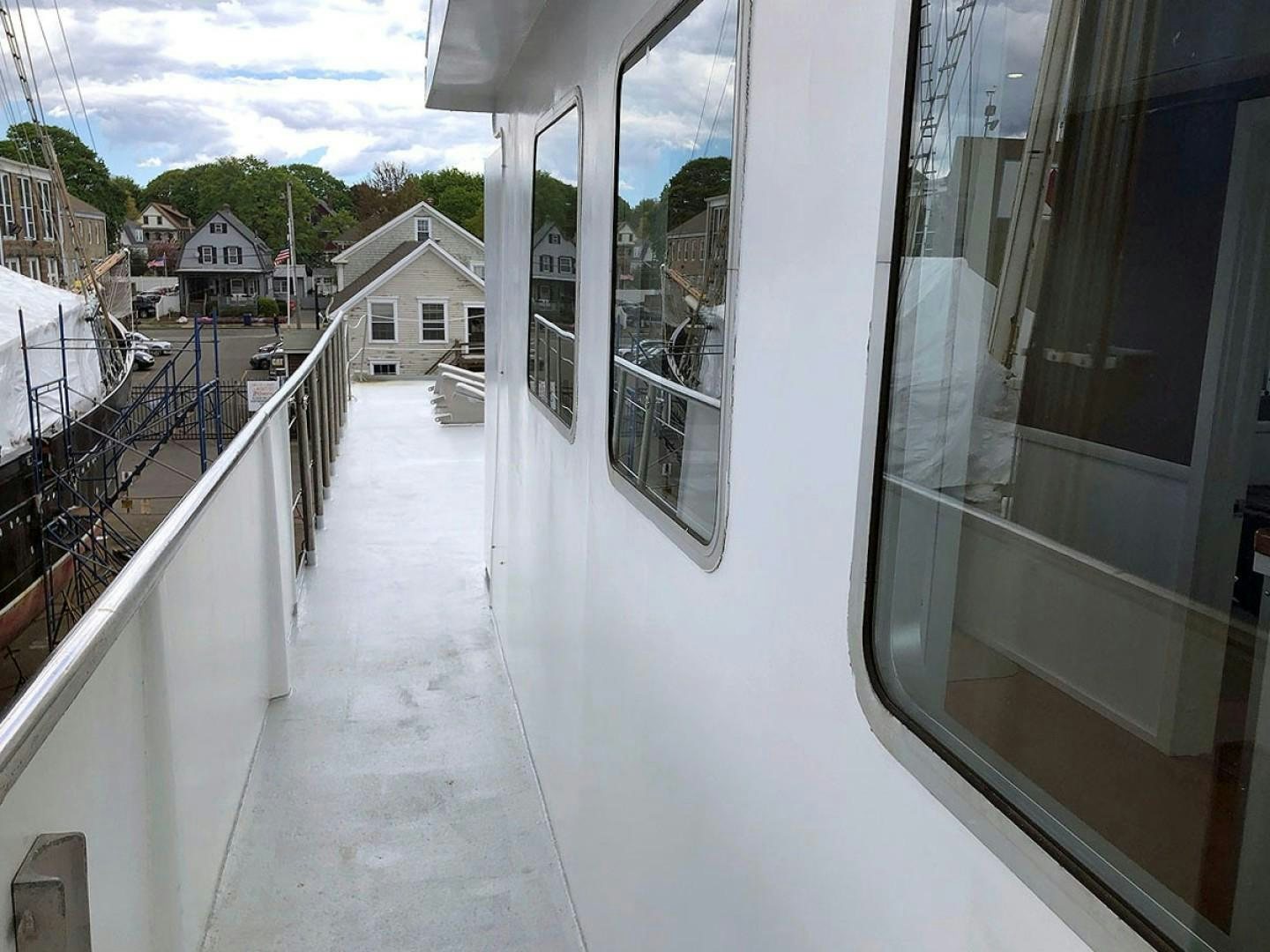 a balcony with a railing and a building with trees and blue sky aboard CARE BEAR Yacht for Sale