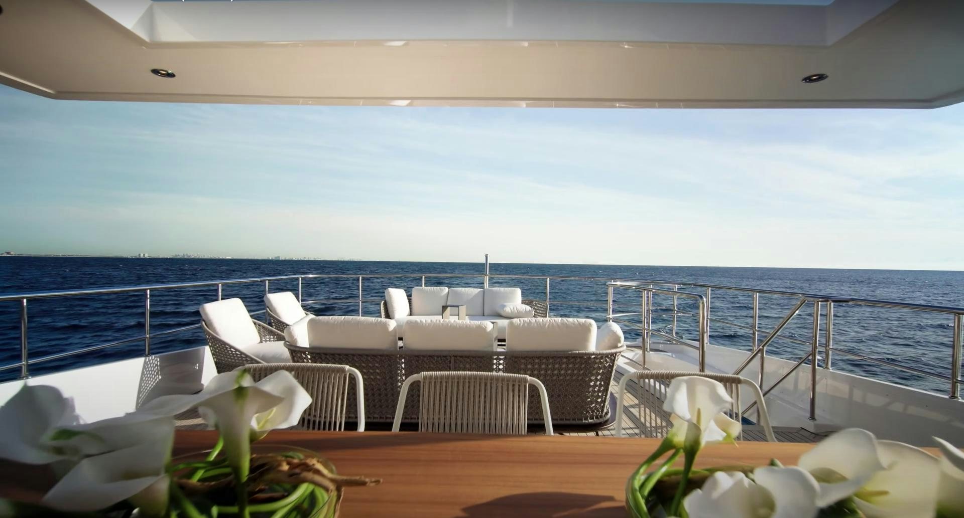 a table with chairs on it aboard Benetti 95 Delfino Yacht for Sale