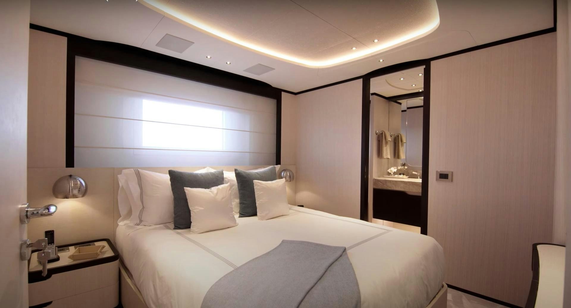 a room with a bed and a mirror aboard Benetti 95 Delfino Yacht for Sale