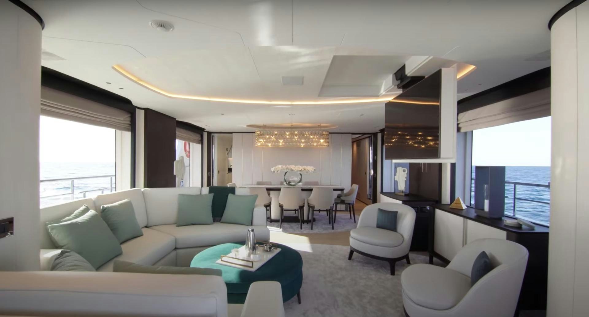 a living room with a couch and a table aboard Benetti 95 Delfino Yacht for Sale