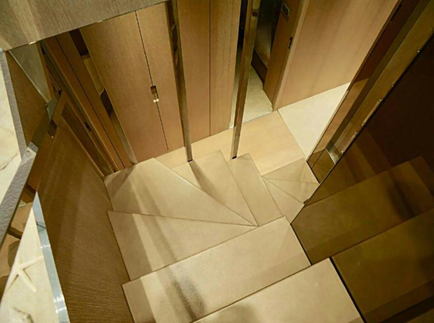 a staircase with white and brown carpet aboard No Name Yacht for Sale