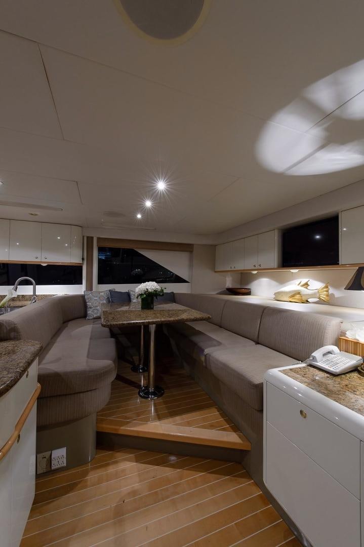 a kitchen with a table and couch aboard BIG WAVE Yacht for Sale