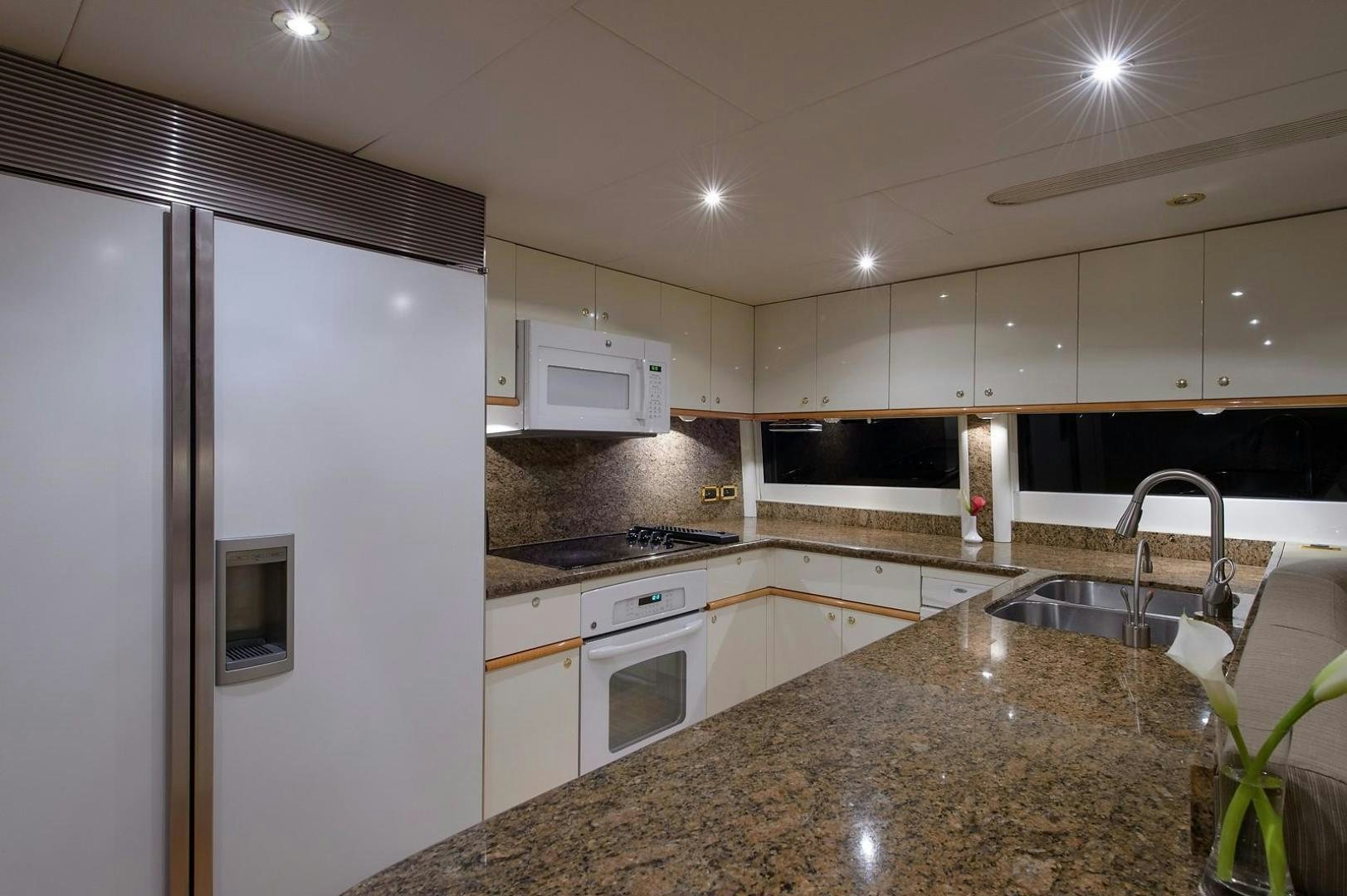 a kitchen with white cabinets aboard BIG WAVE Yacht for Sale