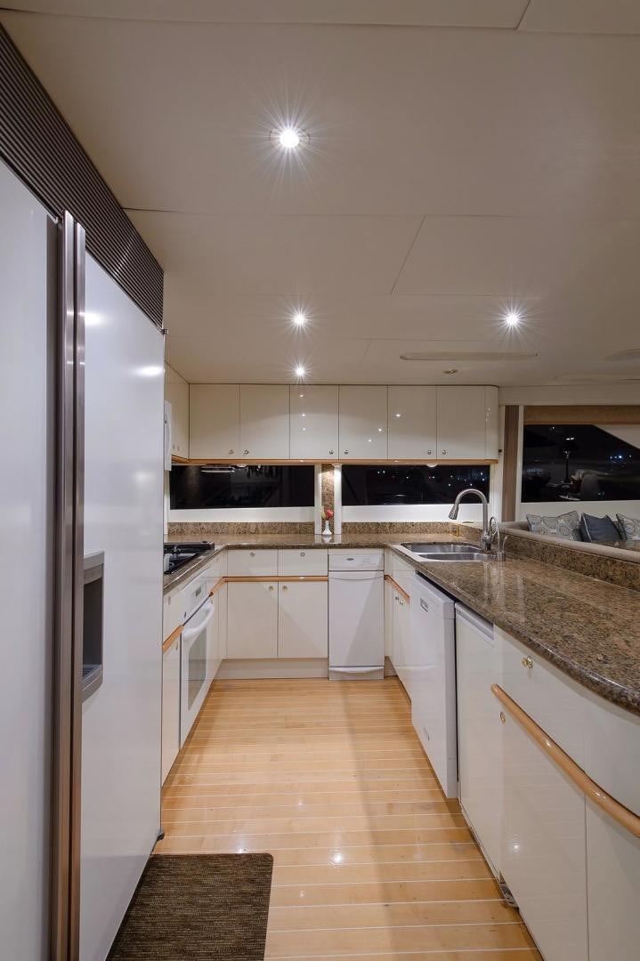 a kitchen with white cabinets aboard BIG WAVE Yacht for Sale