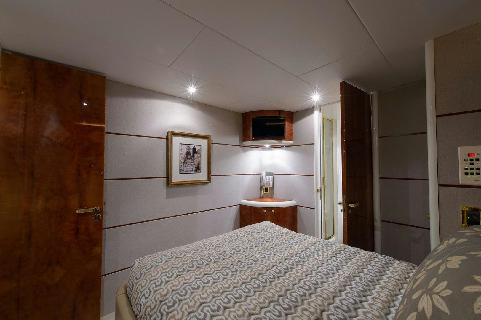 a bedroom with a bed and a television on the wall aboard BIG WAVE Yacht for Sale