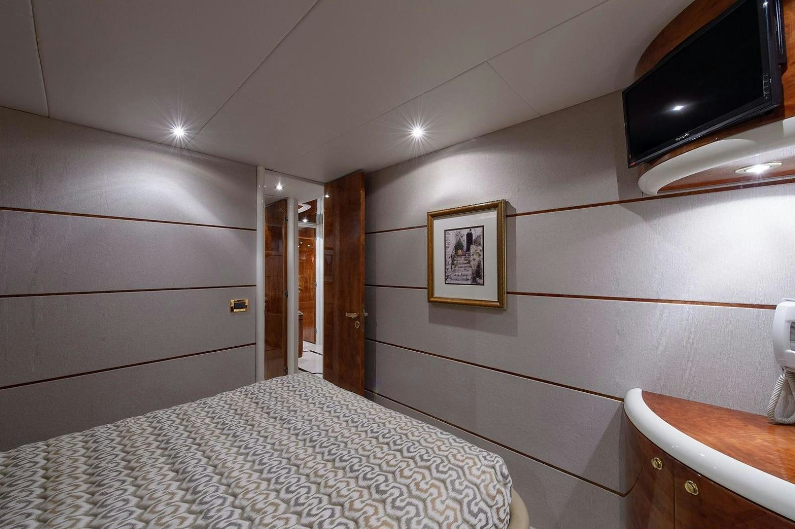 a bedroom with a bed and a television aboard BIG WAVE Yacht for Sale