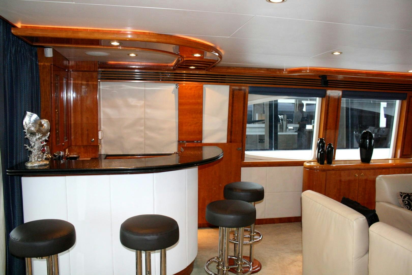 a room with stools and a counter with stools and a window aboard CRYSTAL ANNE Yacht for Sale