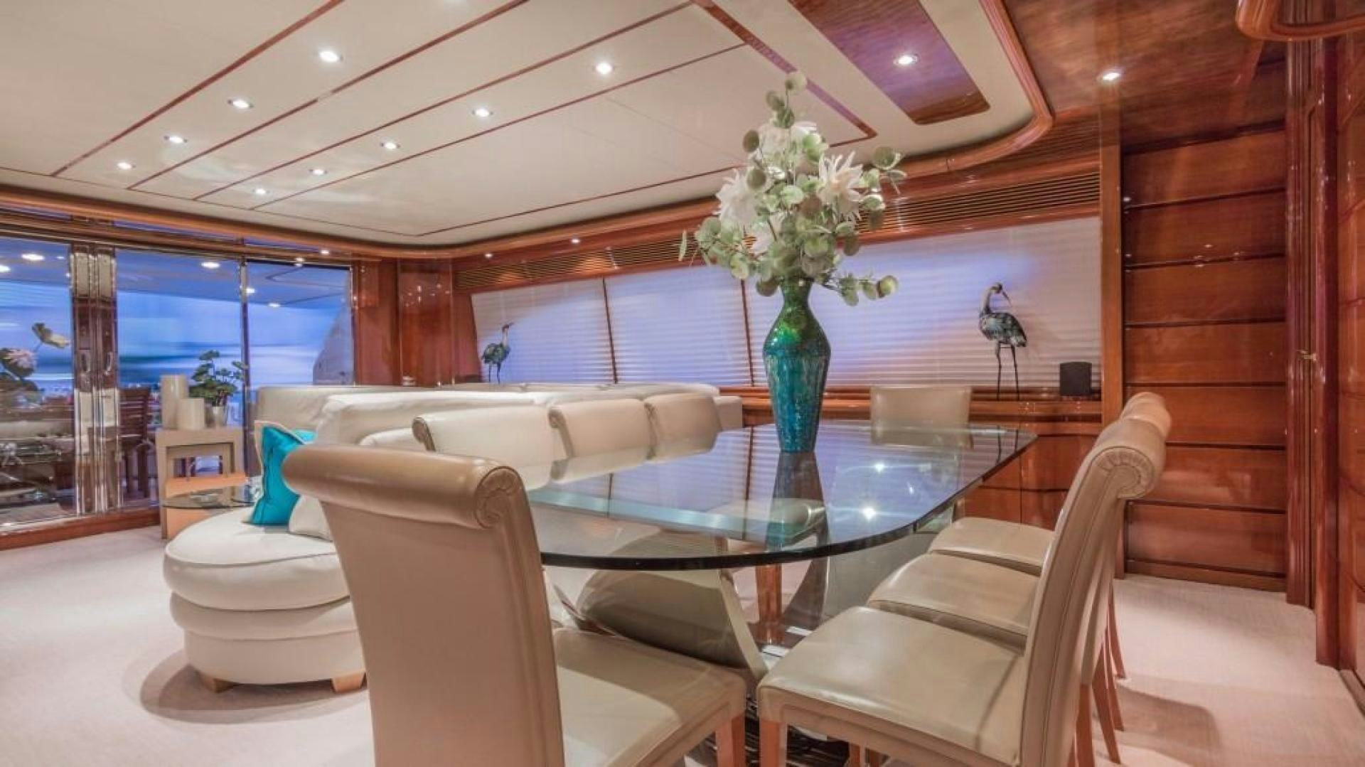 a room with a table chairs and a vase with flowers in it aboard PARADISE Yacht for Sale