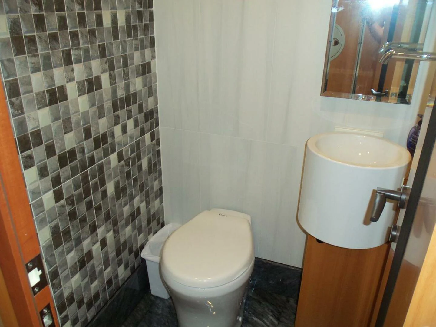 a toilet with a roll of toilet paper on the tank aboard JOHNSON 93 OPEN FB Yacht for Sale