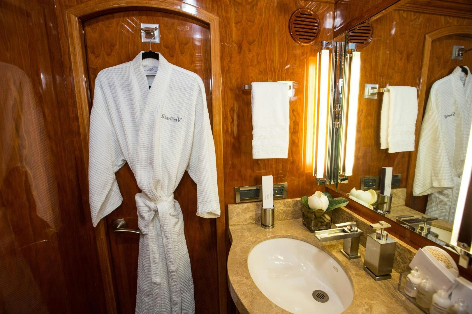 a bathroom with a robe on the wall aboard STERLING V Yacht for Sale